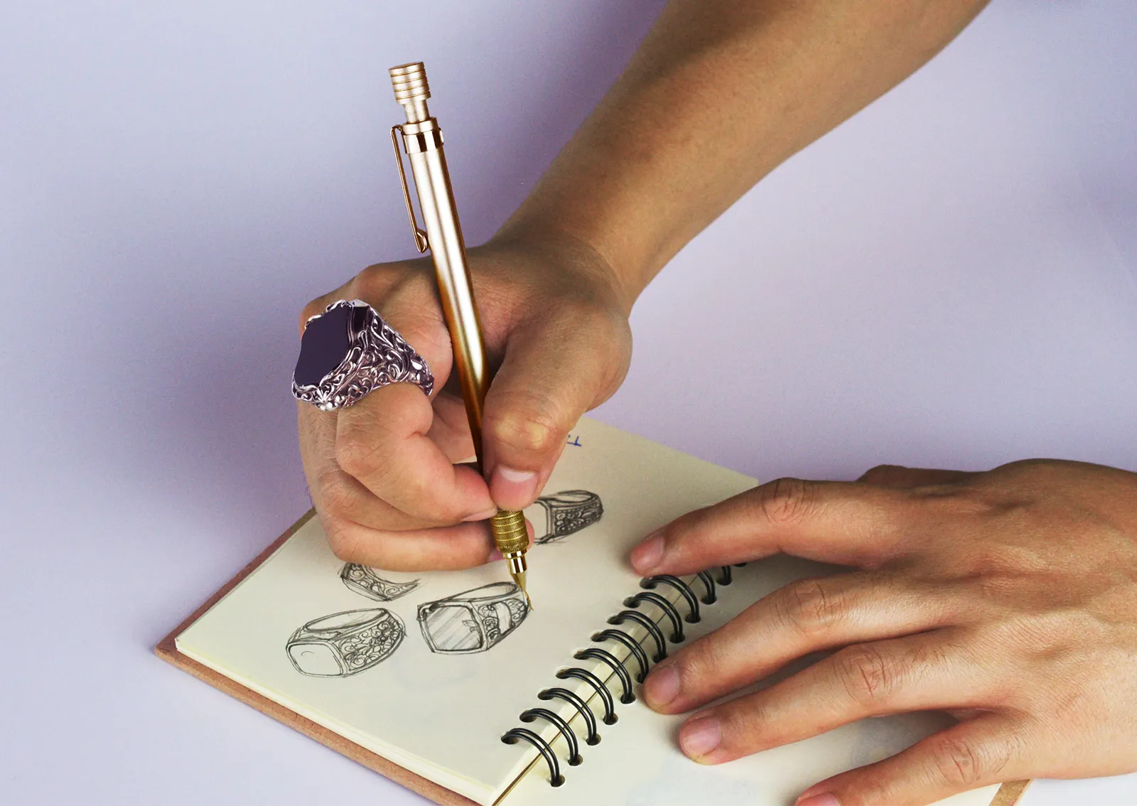 A man sketches a ring in a notebook. How does the custom jewelry design process work from start to finish?
