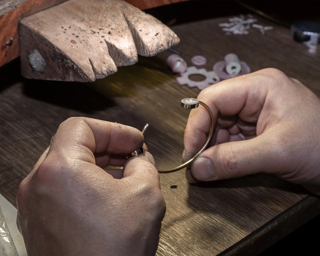 A jeweler at CJD Fine Jewelry is holding a gold bracelet. What’s your refund or cancellation policy for custom jewelry orders?