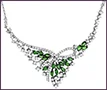 Large custom 18K white gold necklace with abstract floral design, marquise emeralds, and round clear diamonds.